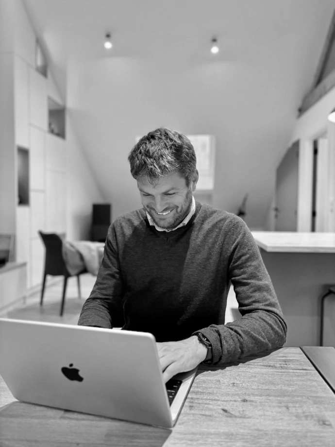 person smiling using MacBook Pro